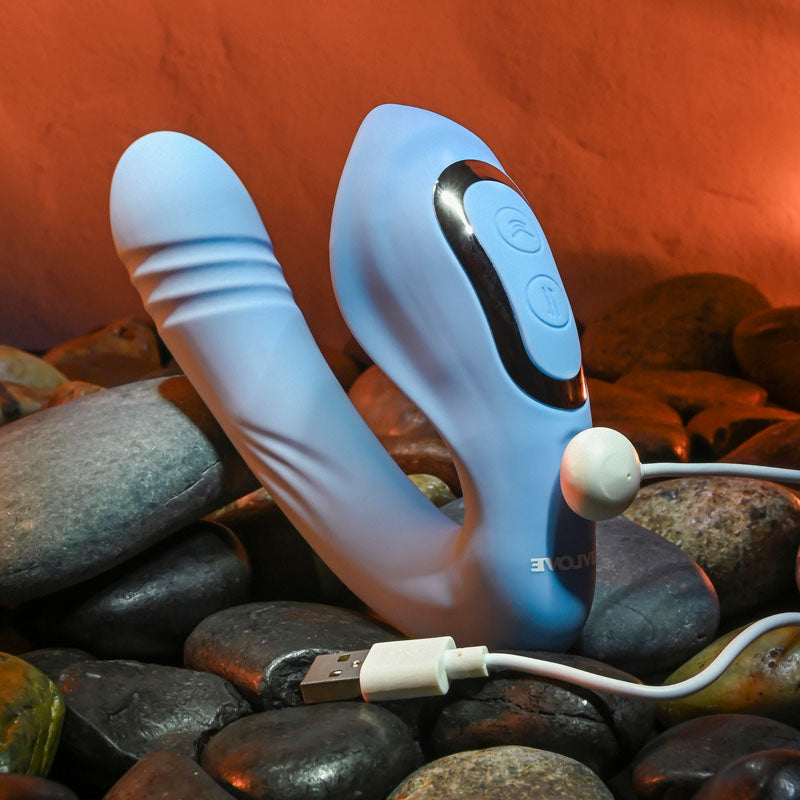 Evolved TAP & THRUST - USB Rechargeable Dual Vibrator on rocks, showcasing its sleek design and USB connection.