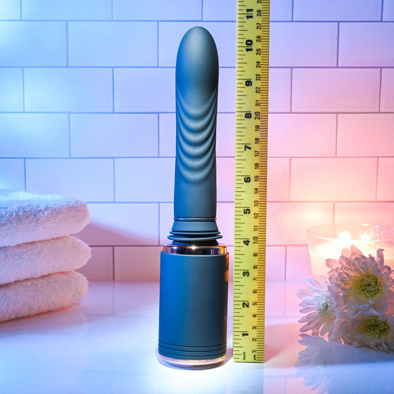 Evolved TOO HOT TO HANDLE - USB Rechargeable Thrusting Vibe with Stand next to a ruler for size reference in a soothing ambiance.