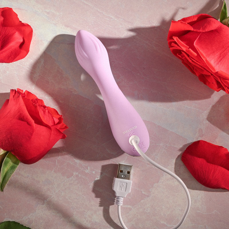 Evolved LILAC G - Lilac 11.5 cm USB Rechargeable Mini Vibrator next to red roses.