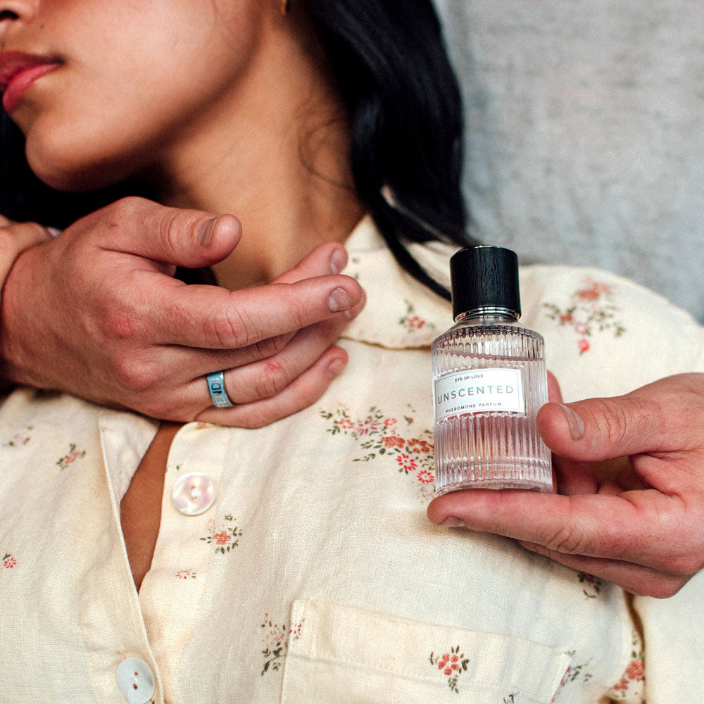 Eye Of Love Unscented Pheromone Perfume - 50 ml - Unisex Pheromone Perfume - 50 ml Spray held near a woman's neck in an intimate setting.
