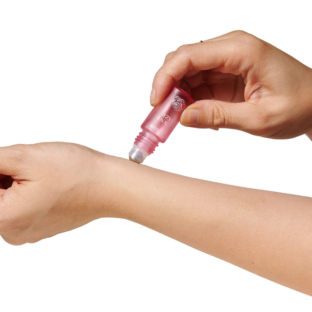 Eye Of Love Love In Bloom Pheromone Perfume Roll-On Set - Day to Night (Sunny Daze & Lilac Dream) Pheromone Perfume Oils for Women to attract Men - 10 ml Roll On Bottles being applied to wrist.