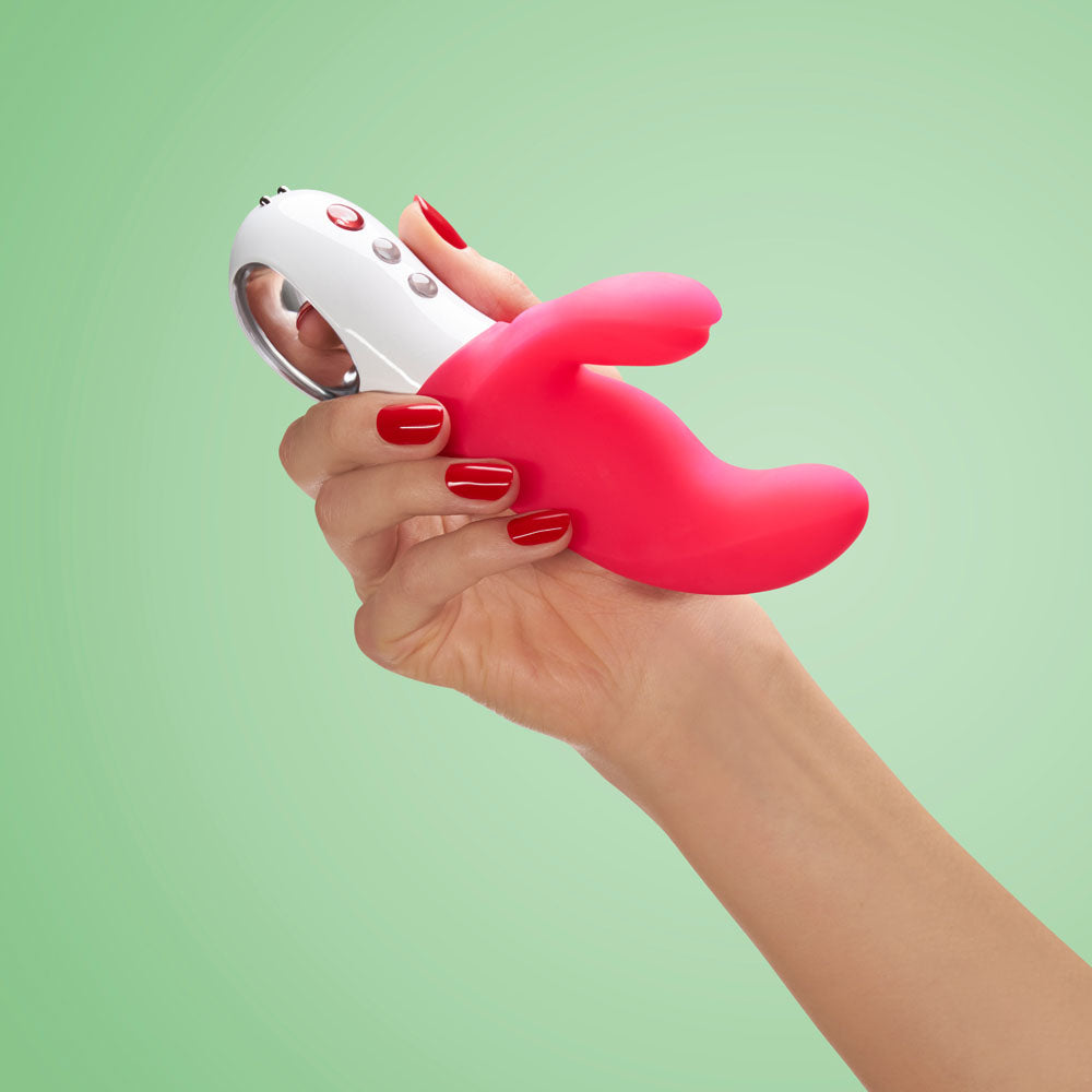 Fun Factory MISS BI - 17 cm USB Rechargeable Rabbit Vibrator held in a hand, showcasing its vibrant design.