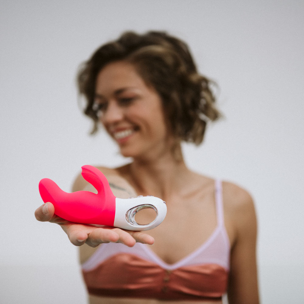 Fun Factory MISS BI  -  17 cm USB Rechargeable Rabbit Vibrator held by a smiling woman, showcasing intimate essentials for her.