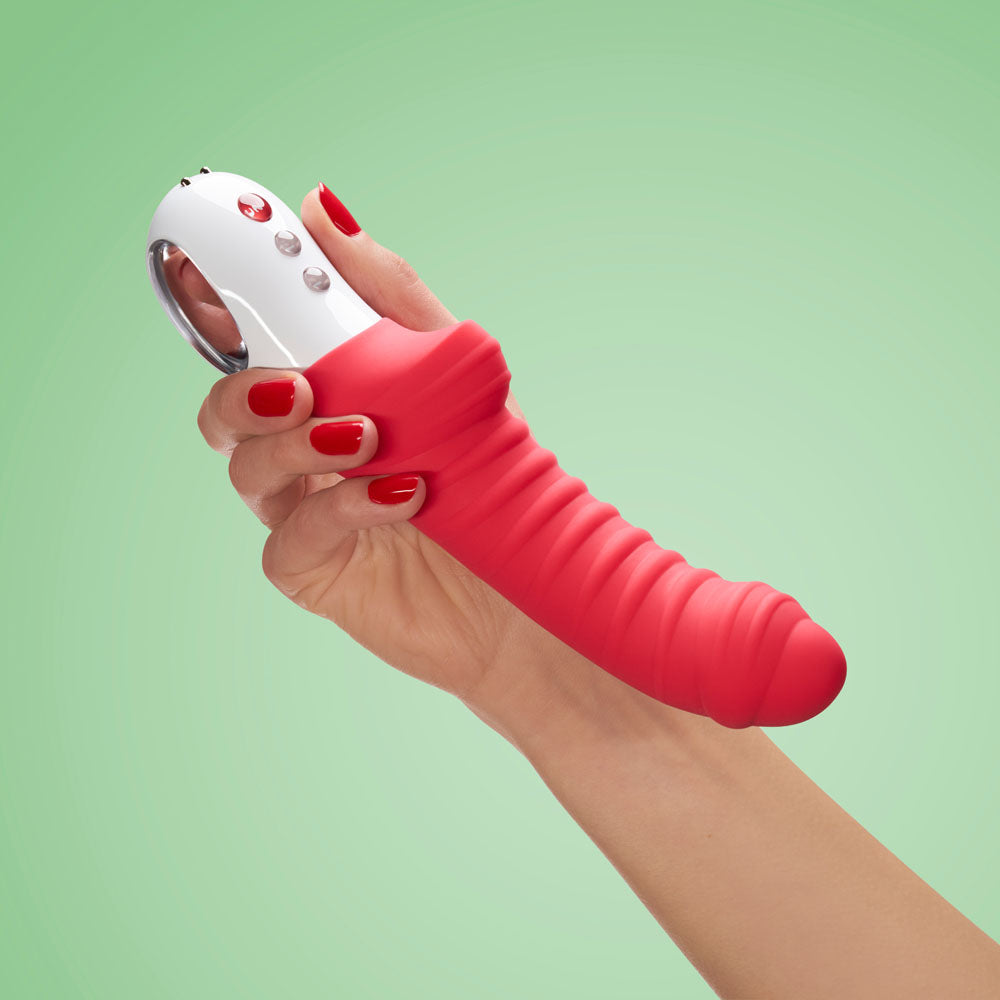 Fun Factory TIGER india - 22.3 USB Rechargeable Vibrator held in a hand with red nails against a green background.