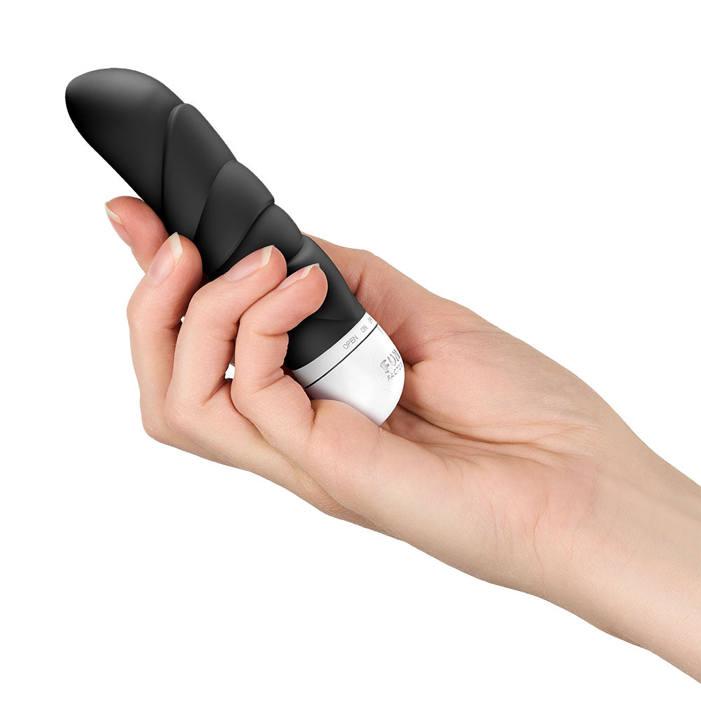 Fun Factory JAM - 12.2 cm Vibrator held in hand, showcasing its ergonomic design and textured shaft for pleasure.