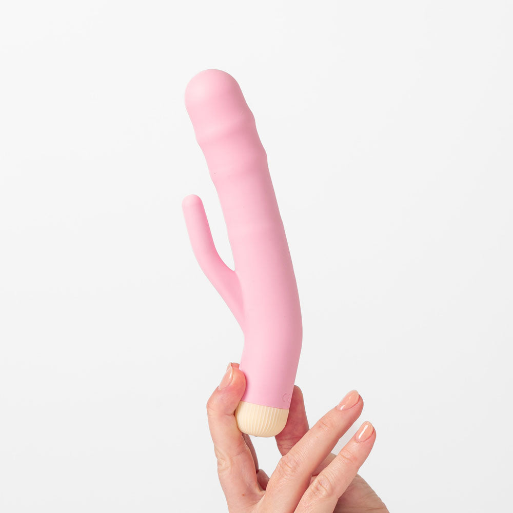 Girls Get Off - DeeDee - 19 cm USB Rechargeable Thrusting Rabbit Vibrator held in hand against a white background.