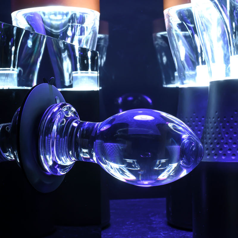 Gender X Crystal Ball -  Glass 13.6 cm Butt Plug with Suction Base showcased in vibrant lighting.