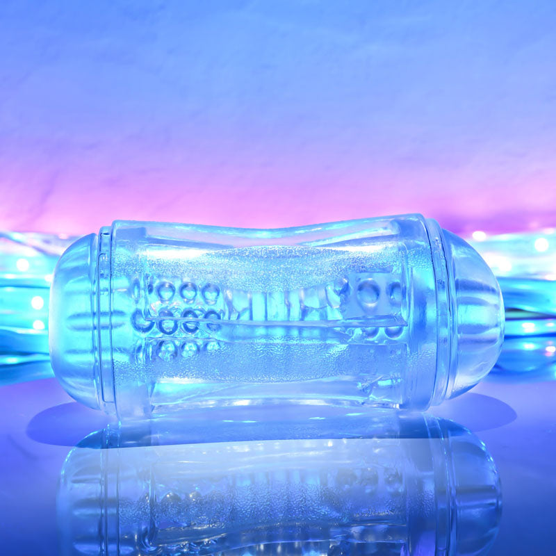 Gender X DOUBLE FANTASY double ended stroker on reflective surface with colorful lighting background.
