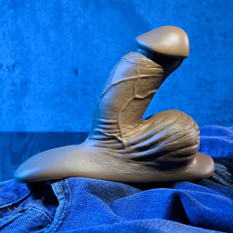 Gender X 4'' SILICONE PACKER DARK -  10 cm Packer on denim surface with blue background for intimate essentials.