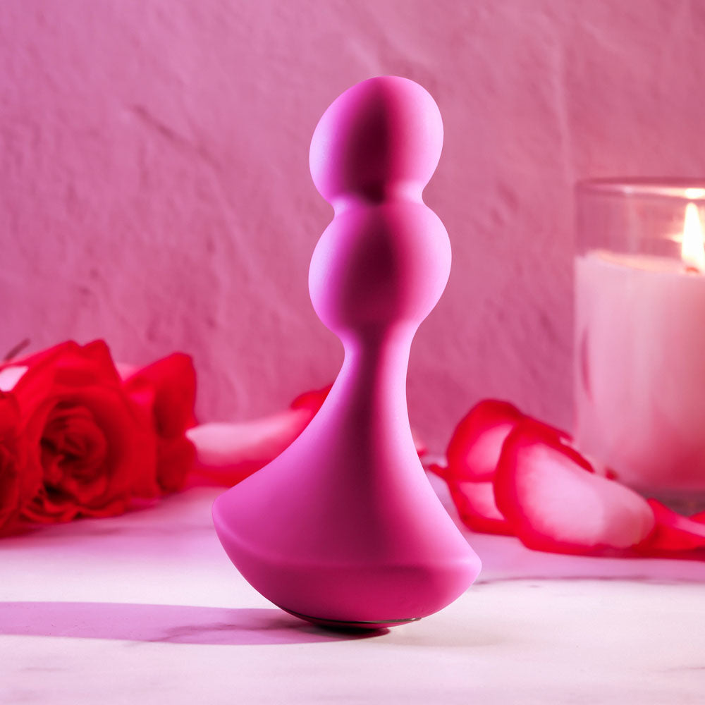Gender X BALL GAME -  13.5 cm USB Rechargeable Vibrating Butt Plug against a romantic backdrop with roses.
