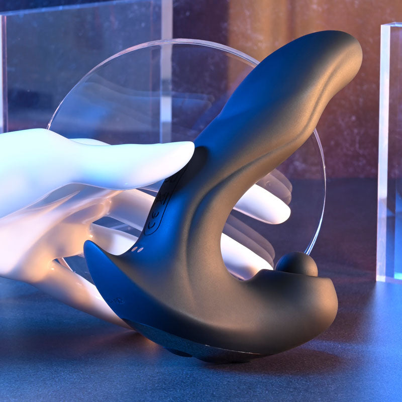 Gender X MAD TAPPER -  USB Rechargeable Double Tapping Vibrating Massager displayed on a surface with hand gently holding it.