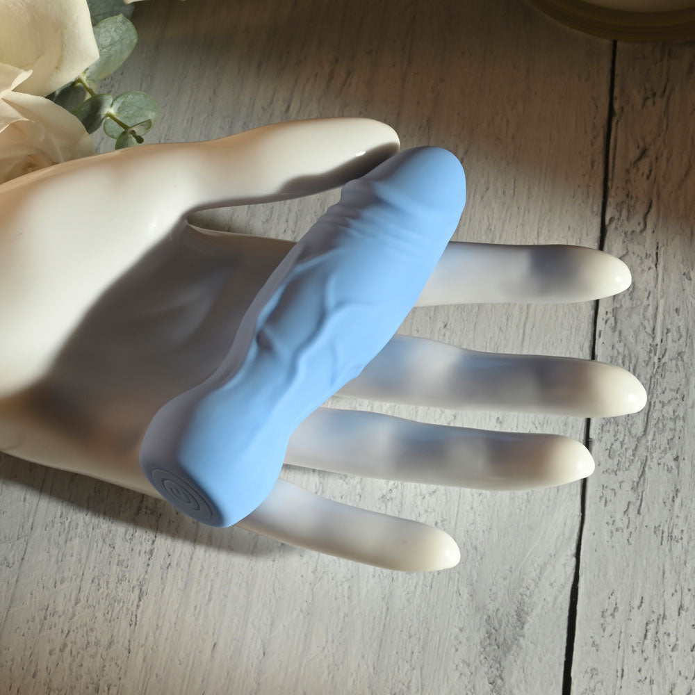 Gender X LIL BUDDY - Light 10.1 cm USB Rechargeable Mini Vibrator displayed on a hand against a rustic background.