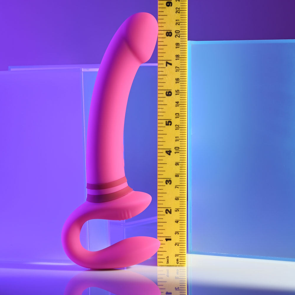 Gender X SHARING IS CARING - 21.9 cm USB Rechargeable Strapless Strap-On shown against a measuring tape in vibrant lighting.