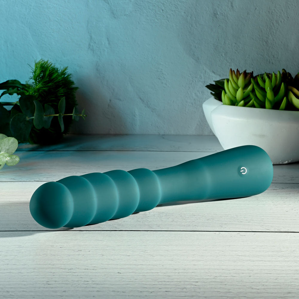Gender X SCORPION - 21.2 cm USB Rechargeable Vibrator displayed on a wooden surface with greenery.