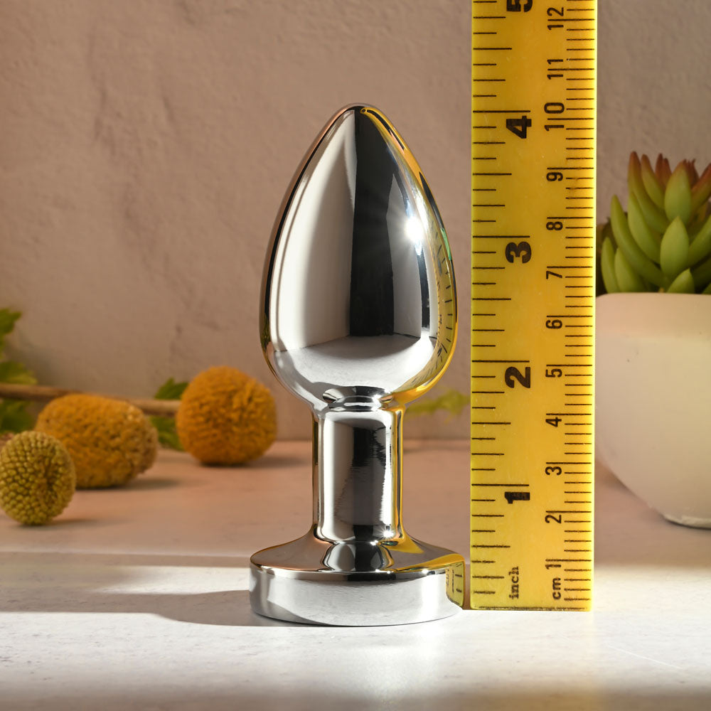 Gender X ROCKIN METAL PLUG XL -  10.5 cm USB Rechargeable Vibrating XL Butt Plug next to a measuring tape.