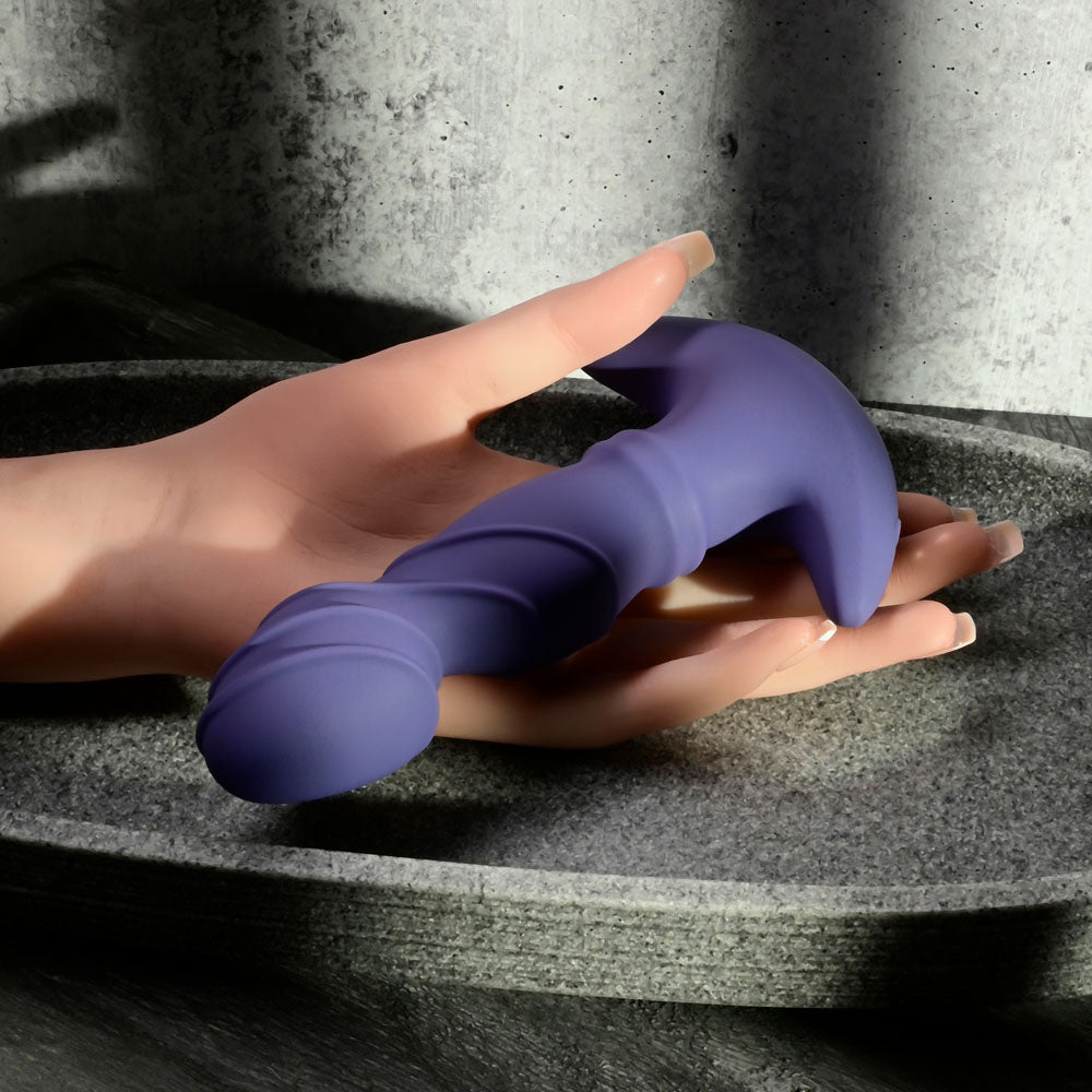 USB rechargeable vibrator with remote held in a hand, showcasing its textured design and ergonomic shape.