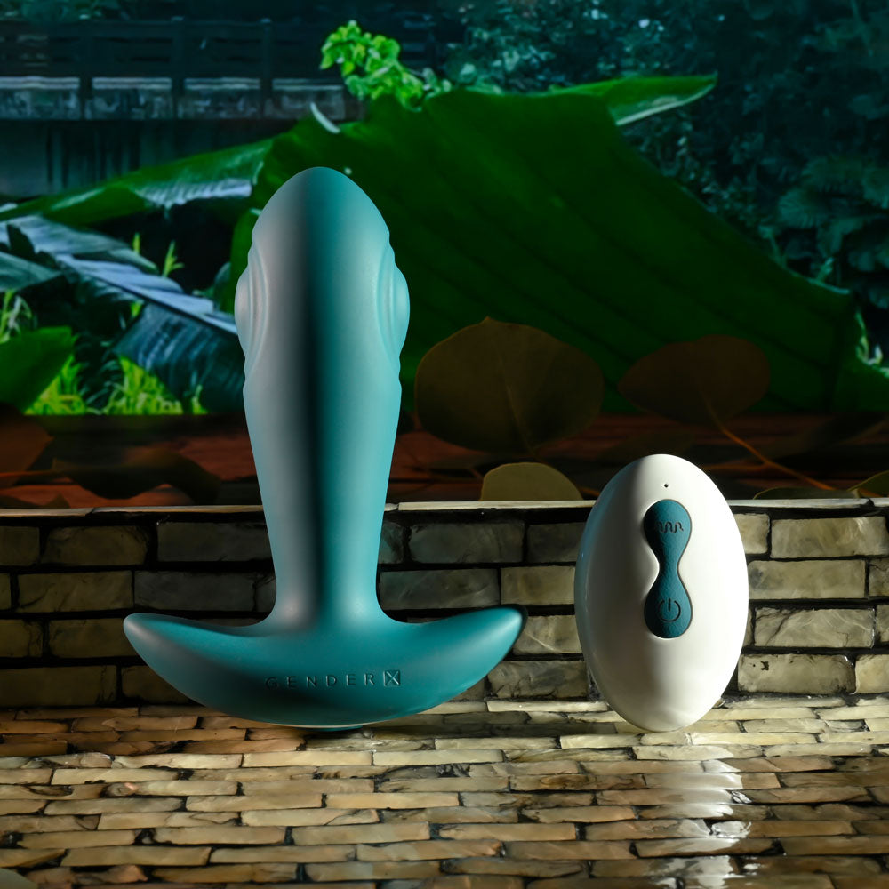 Gender X TUNNEL TAPPER - Grey 12.1 cm USB Rechargeable Tapping Anal Plug with Wireless Remote displayed outdoors.