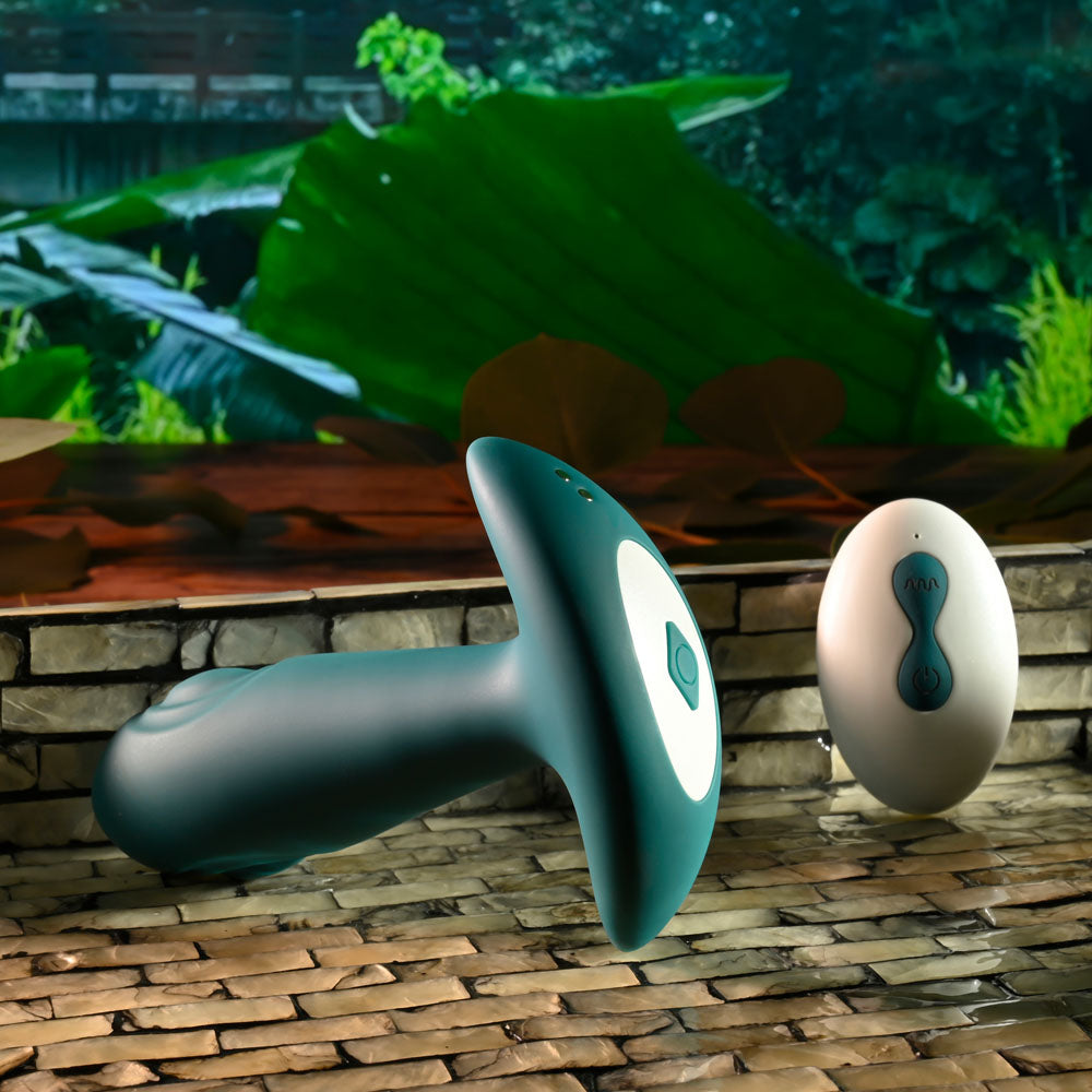 Gender X TUNNEL TAPPER - Grey 12.1 cm USB Rechargeable Tapping Anal Plug with Wireless Remote displayed in a natural setting.