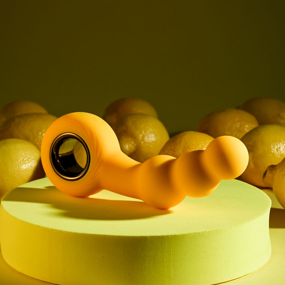 Gender X BUMBLE - 14.9 cm USB Rechargeable Butt Plug on a vibrant background with lemons.