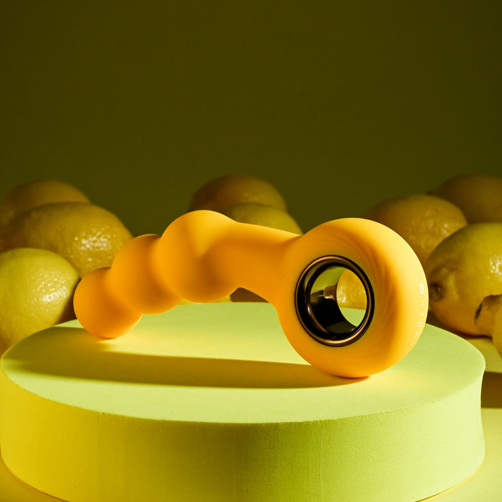 Gender X BUMBLE -  14.9 cm USB Rechargeable Butt Plug on a yellow surface with lemons in the background.