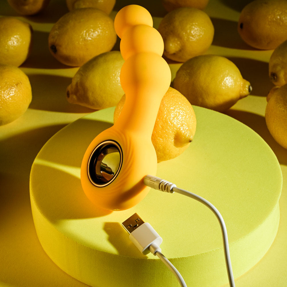 Gender X BUMBLE -  14.9 cm USB Rechargeable Butt Plug against a vibrant yellow backdrop with lemons.