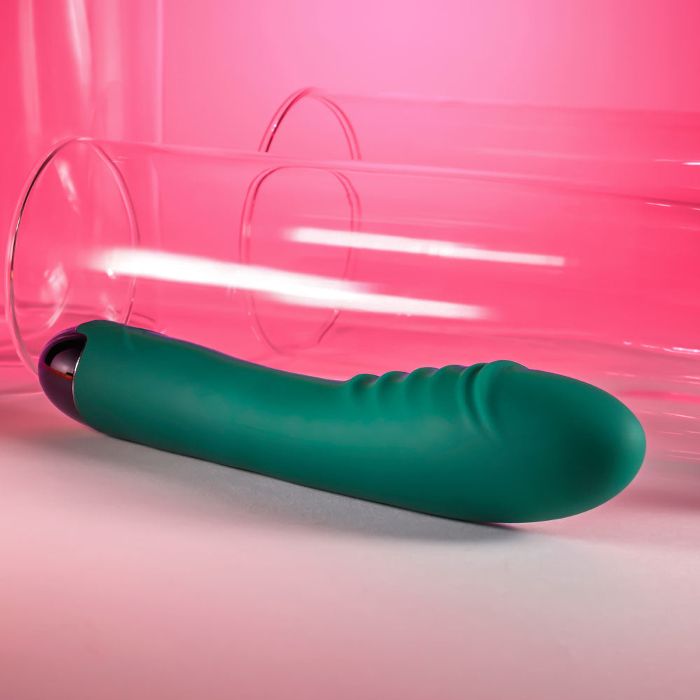 Gender X PIROUETTE -  20.6 cm USB Rechargeable Vibrator in teal resting next to clear glass tubes