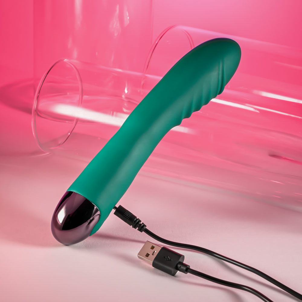 Gender X PIROUETTE - 20.6 cm USB Rechargeable Vibrator on charging cable with pink background