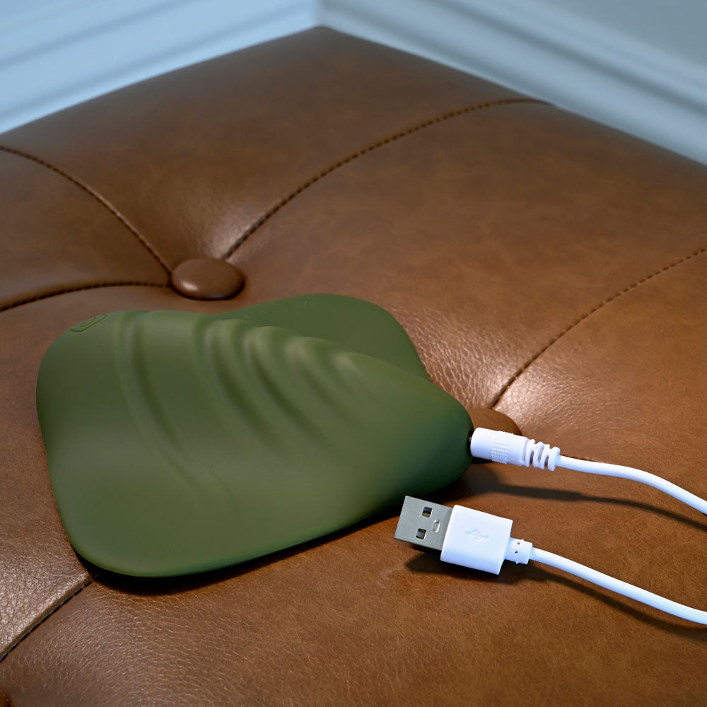Gender X PLEASURE PAD - USB Rechargeable Grinding Pad connected with a USB cable on a leather surface.