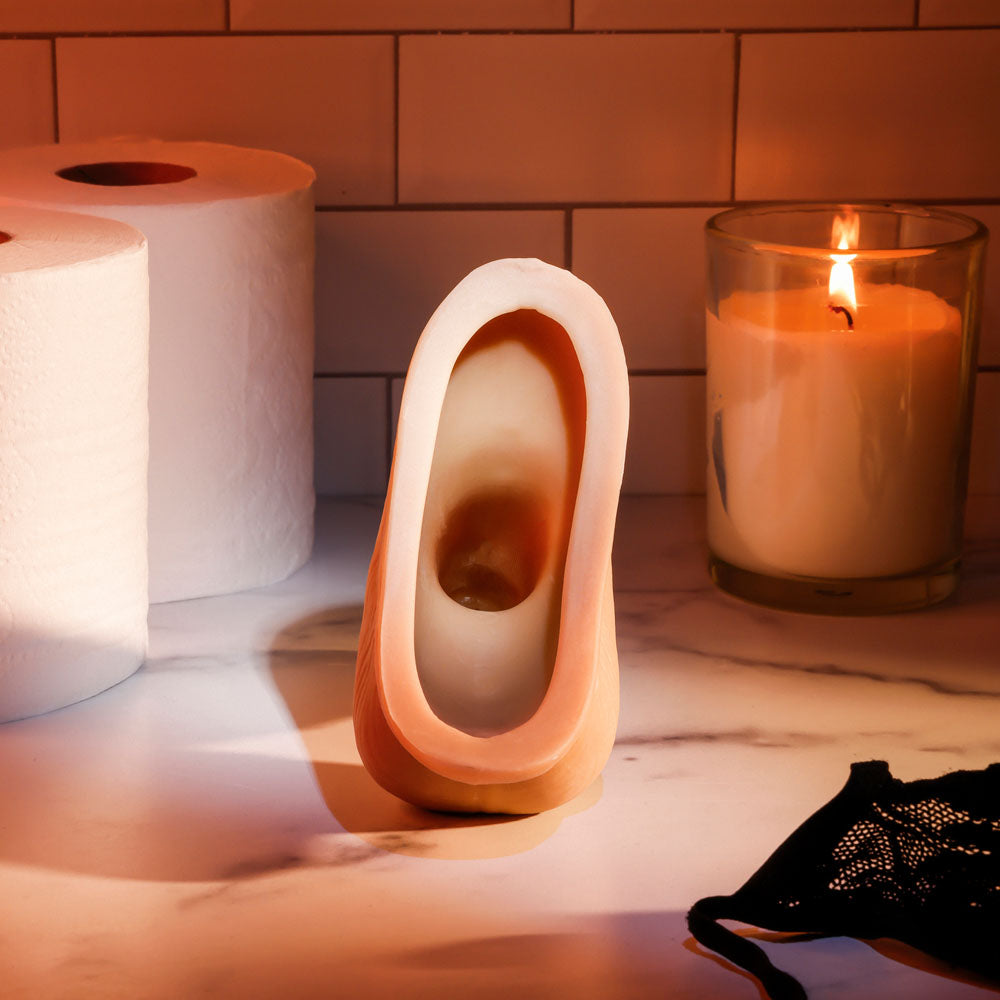 Gender X STAND TO PEE - Light - Realistic Stand-To-Pee Funnel on a marble surface with a candle and paper towels.
