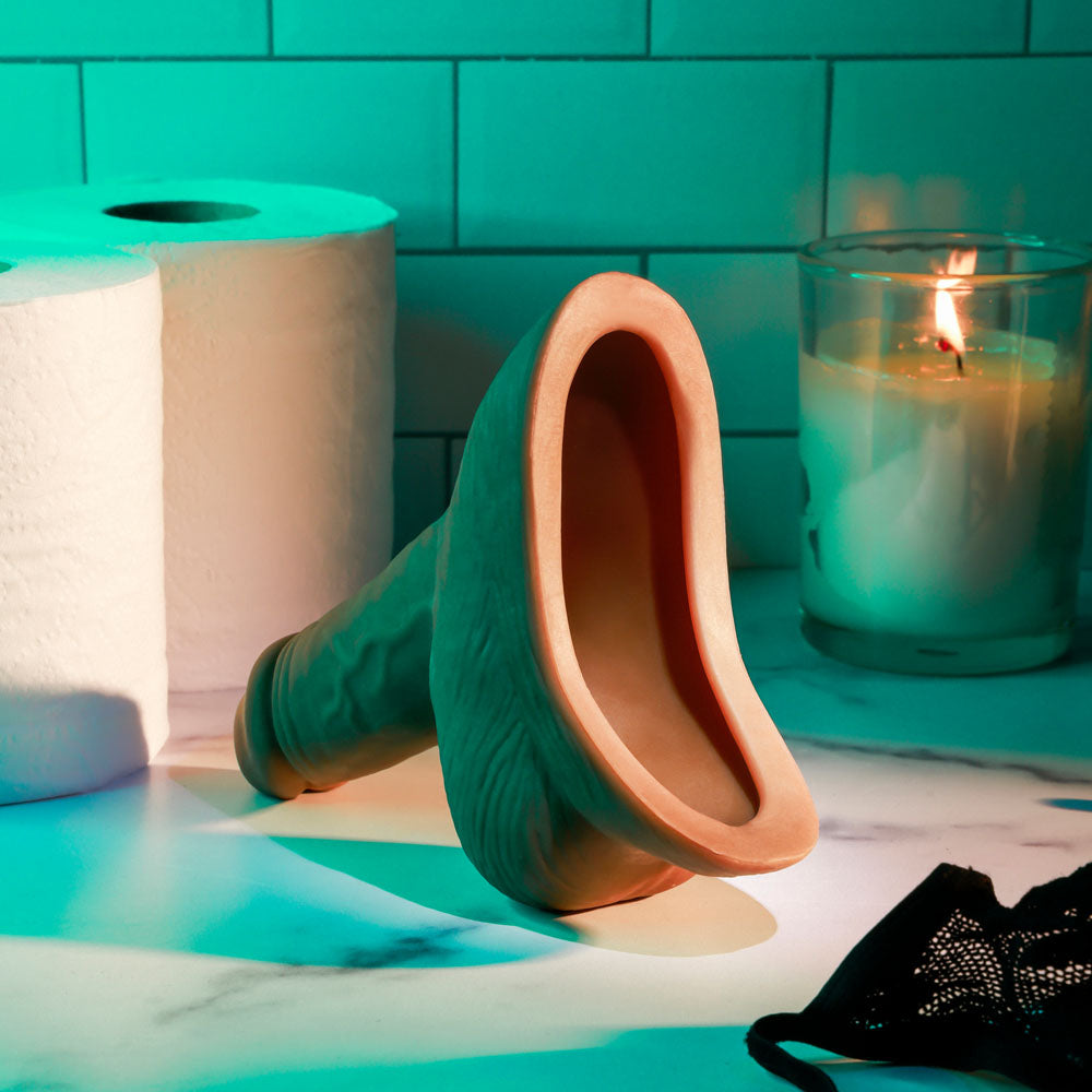 Gender X STAND TO PEE - Dark -  Realistic Stand-To-Pee Funnel placed on a marble countertop with candles and toilet paper.