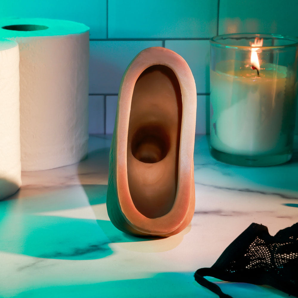 Gender X STAND TO PEE - Dark -  Realistic Stand-To-Pee Funnel on a counter with candles and fabric.