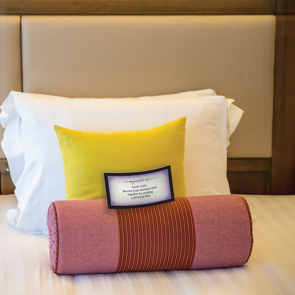 Adventurous Sex Coupons - Set of 15 Coupons displayed elegantly on a neatly made bed with colorful cushions.