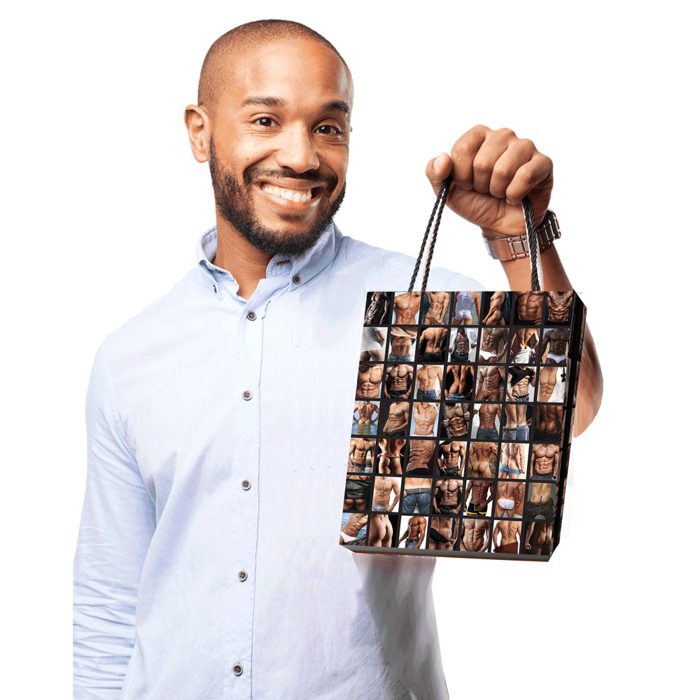 A person holding a Sexy Guys Gift Bag - Novelty Gift Bag featuring various male images, perfect for fun and intimate gifts.