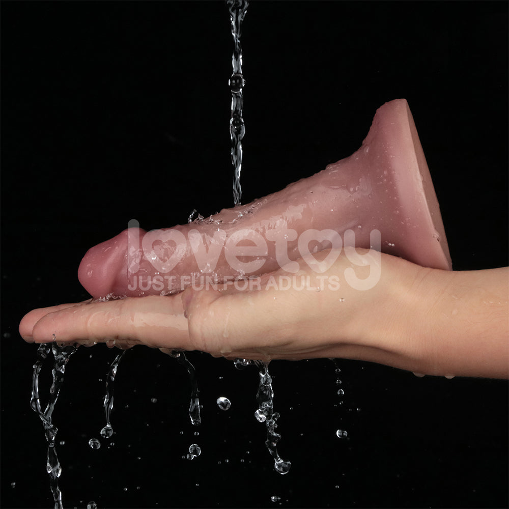 Dual Density Power Cock - 6 Inch  -  16 cm USB Rechargeable Vibrating Dong held in hand with water splashing on it.