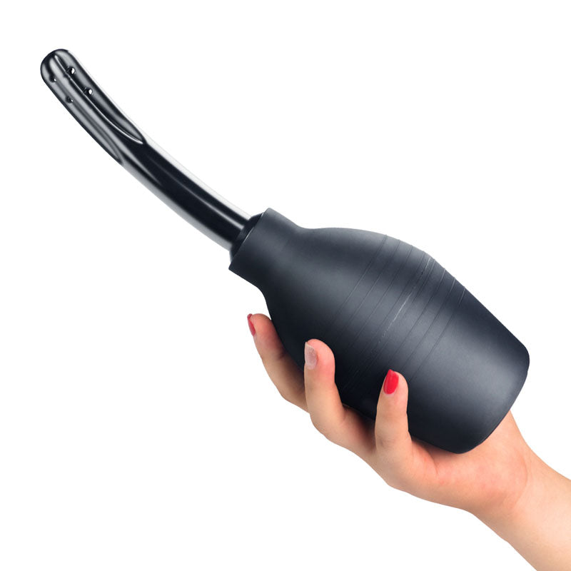 Bondage Fetish Deluxe Douche -  Unisex Curved Douche - 310 ml capacity held in a hand, showcasing its sleek design.