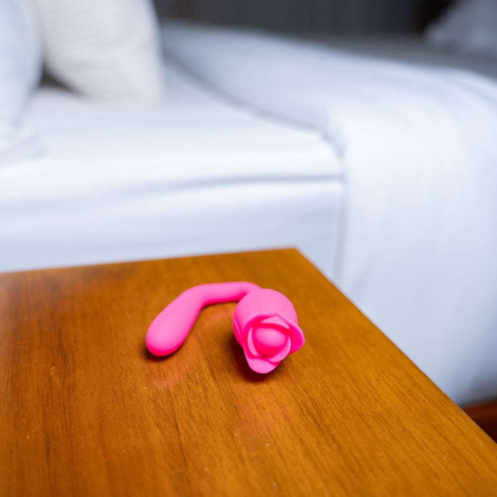 Maia MEADOW -  14 cm USB Rechargeable Flower Stimulator on a wooden bedside table next to a bed.