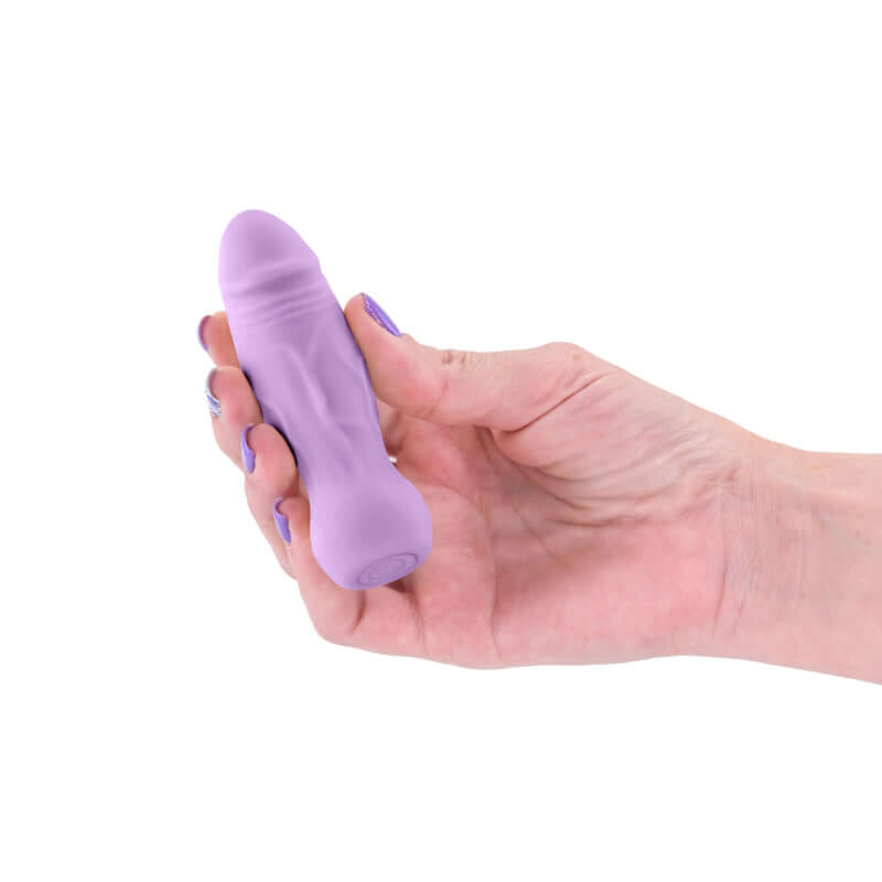 Hand holding X & O's Peck - Lavender 9.9 cm USB rechargeable bullet vibrator, showcasing its sleek design.