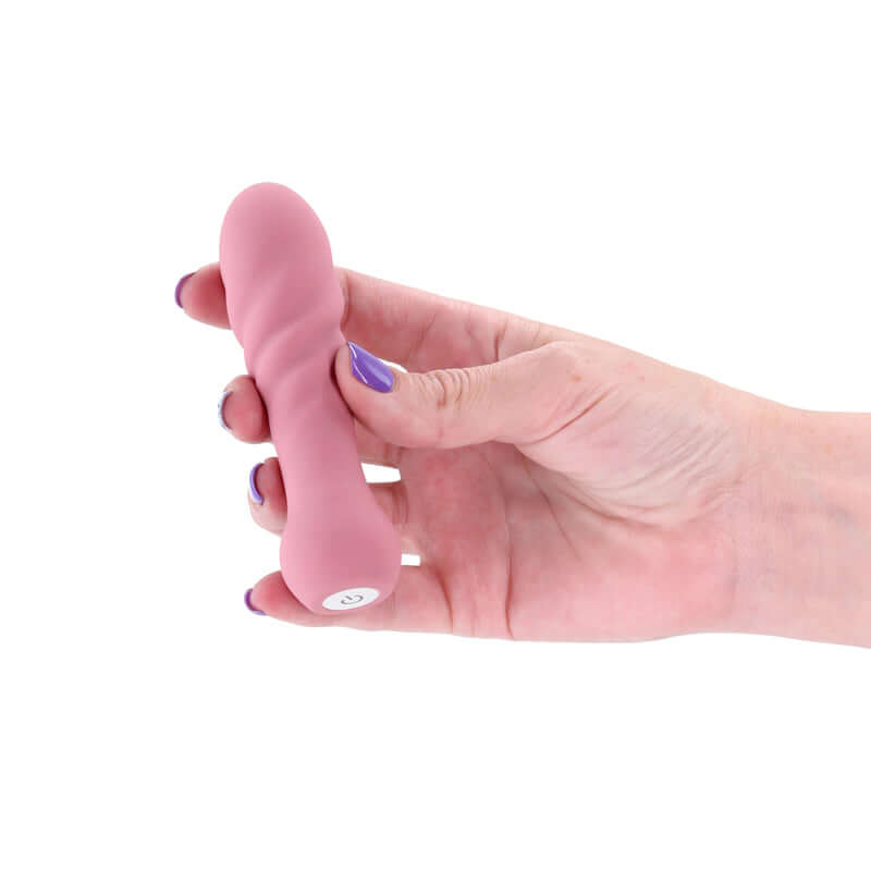 X & O's Love dusty rose USB rechargeable bullet vibrator held in hand, premium silicone, compact, and waterproof.