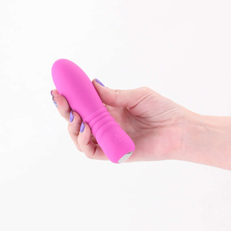 USB rechargeable vibrator held in hand, featuring a sleek design and vibrant pink silicone material.
