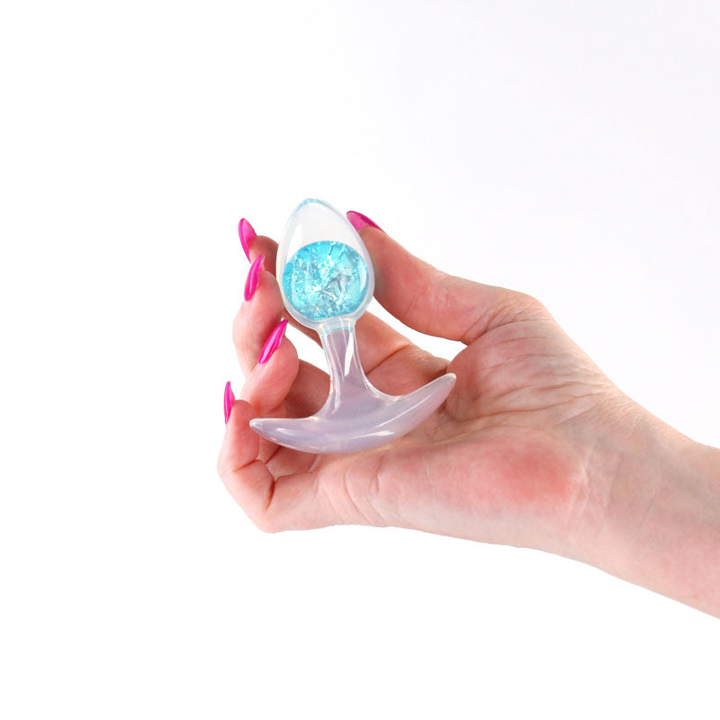 Glams Cosmic - Small -  - Clear/ 8.1 cm Small Butt Plug held in hand with sparkly internal glass marble.