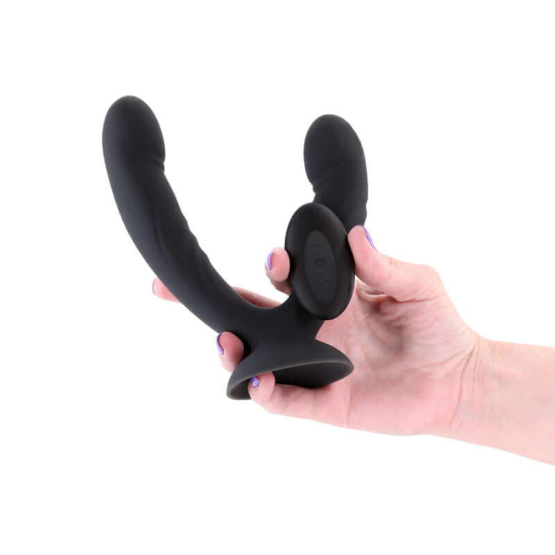 INYA Duet USB rechargeable vibrating double dildo held in hand, featuring a suction cup base and remote control.