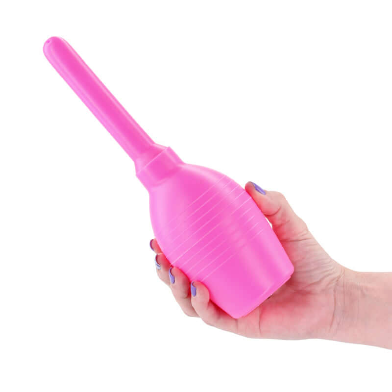 INYA Body Cleanser 2.0, a unisex intimate body cleanser, showcased in a hand with a pink squeezable bulb and nozzle.