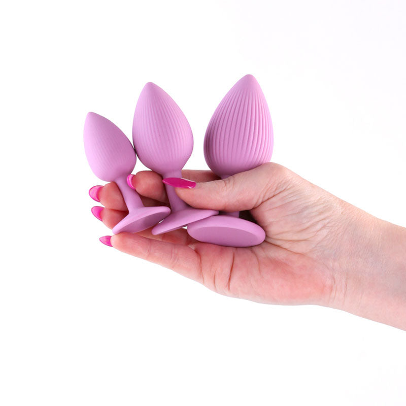 INYA Triple Ace Kit - Blush -  Butt Plugs - Set of 3 Sizes held in hand, showcasing their size and texture.