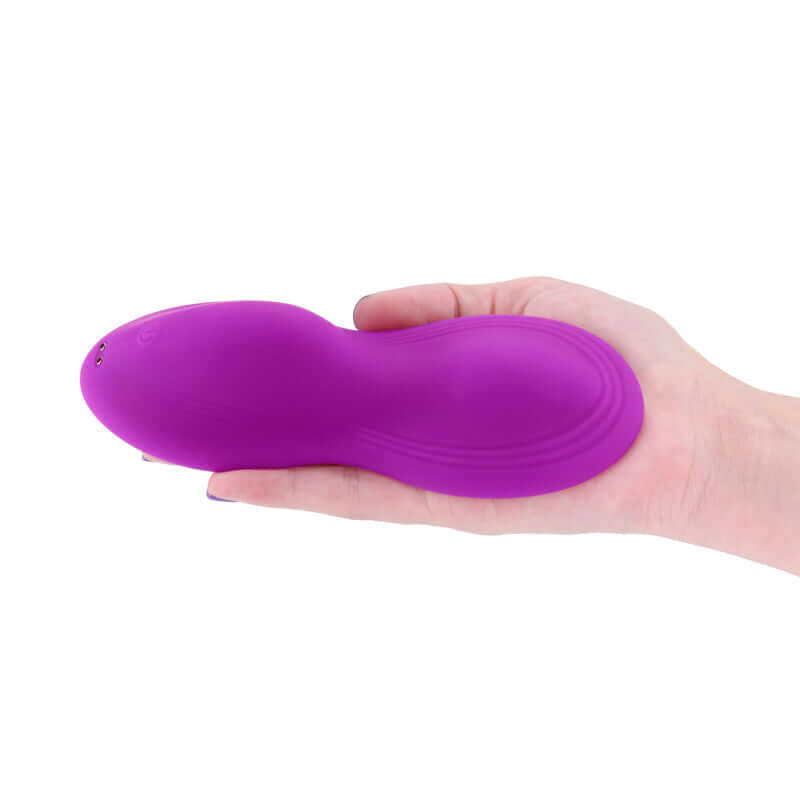 USB rechargeable vibrating grinder pad held in hand, showcasing its plush silicone and sleek design.