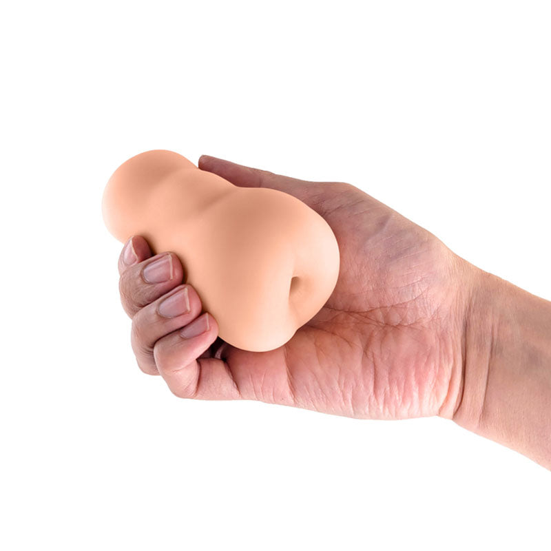 Pocket Pals Anal Stroker - Tan - Tan Anal Stroker held in a hand, showcasing its compact design and realistic texture.