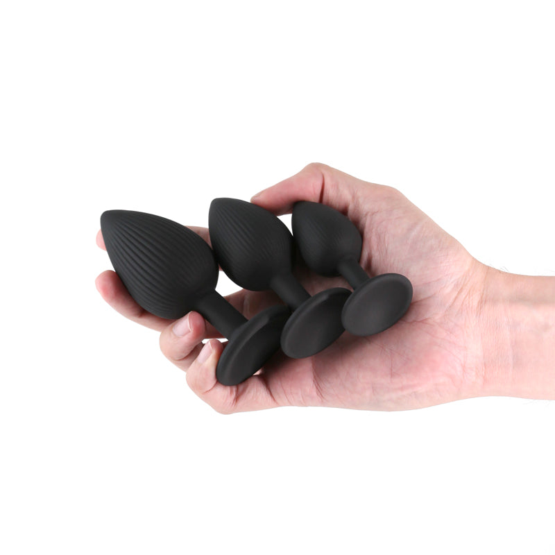 Renegade Triple Ace Kit -  -  Butt Plugs - Set of 3 Sizes held in hand with textured and smooth designs.