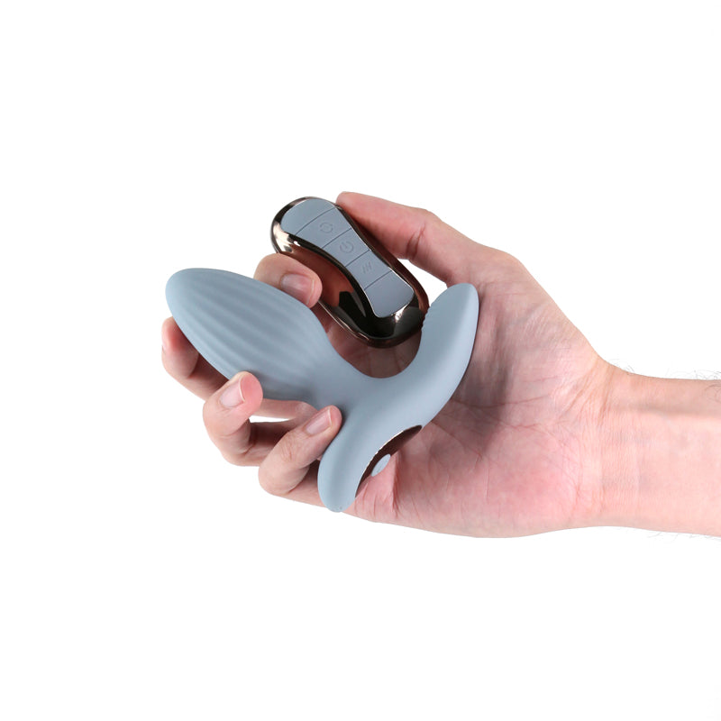 Renegade Summit - Grey - Grey 10.2 cm USB Rechargeable Vibrating Butt Plug with Remote held in hand.