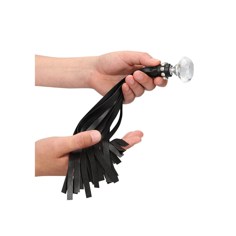 OUCH! Diamond Studded Whip - Whip held in hand, showcasing glamourous diamond and leather design for intimate essentials.