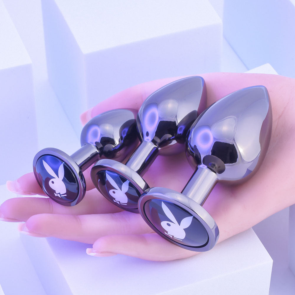 Playboy Pleasure PLEASURE 3 WAYS - Metal Butt Plugs - Set of 3 Sizes in a hand, showcasing intimate essentials.