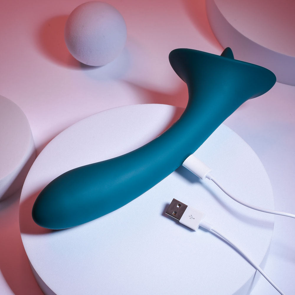 Playboy Pleasure TRUE INDULGENCE - Teal 21.3 cm USB Rechargeable Vibrator with Flicking Tip on a minimalist background.